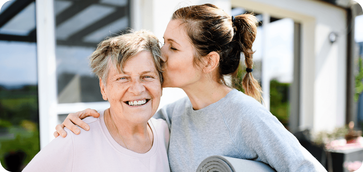 A daughter kissing her mother on the cheek